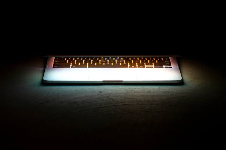 Laptop mit beleuchteter Tastatur in einem dunklen Raum